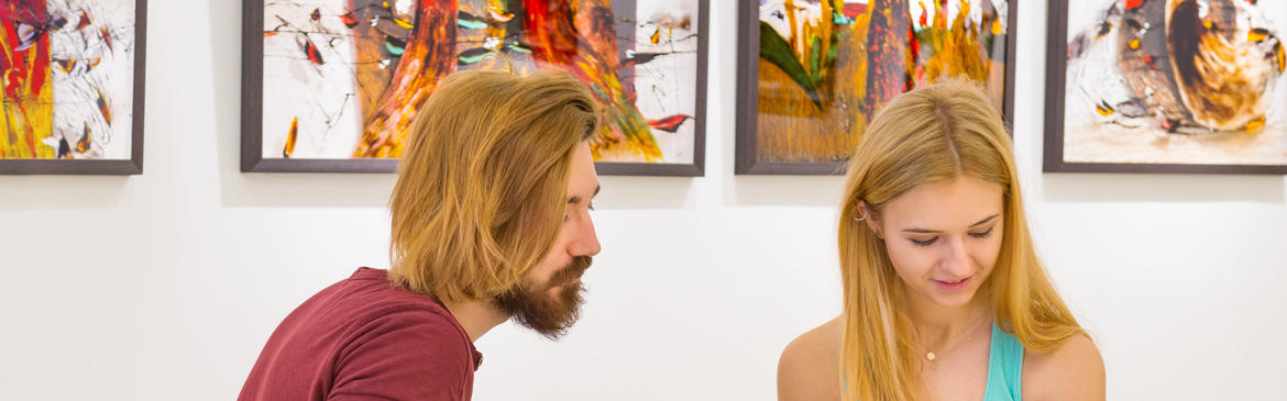 couple sitting in front of prints at a gallery